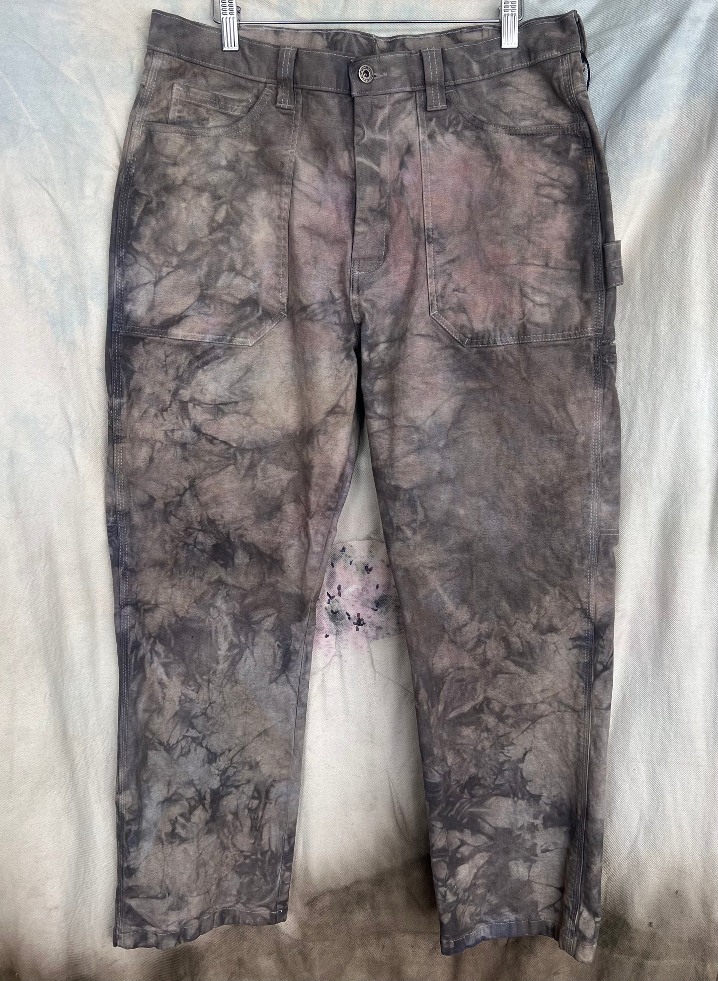 Camouflage pants hanging on a white background
