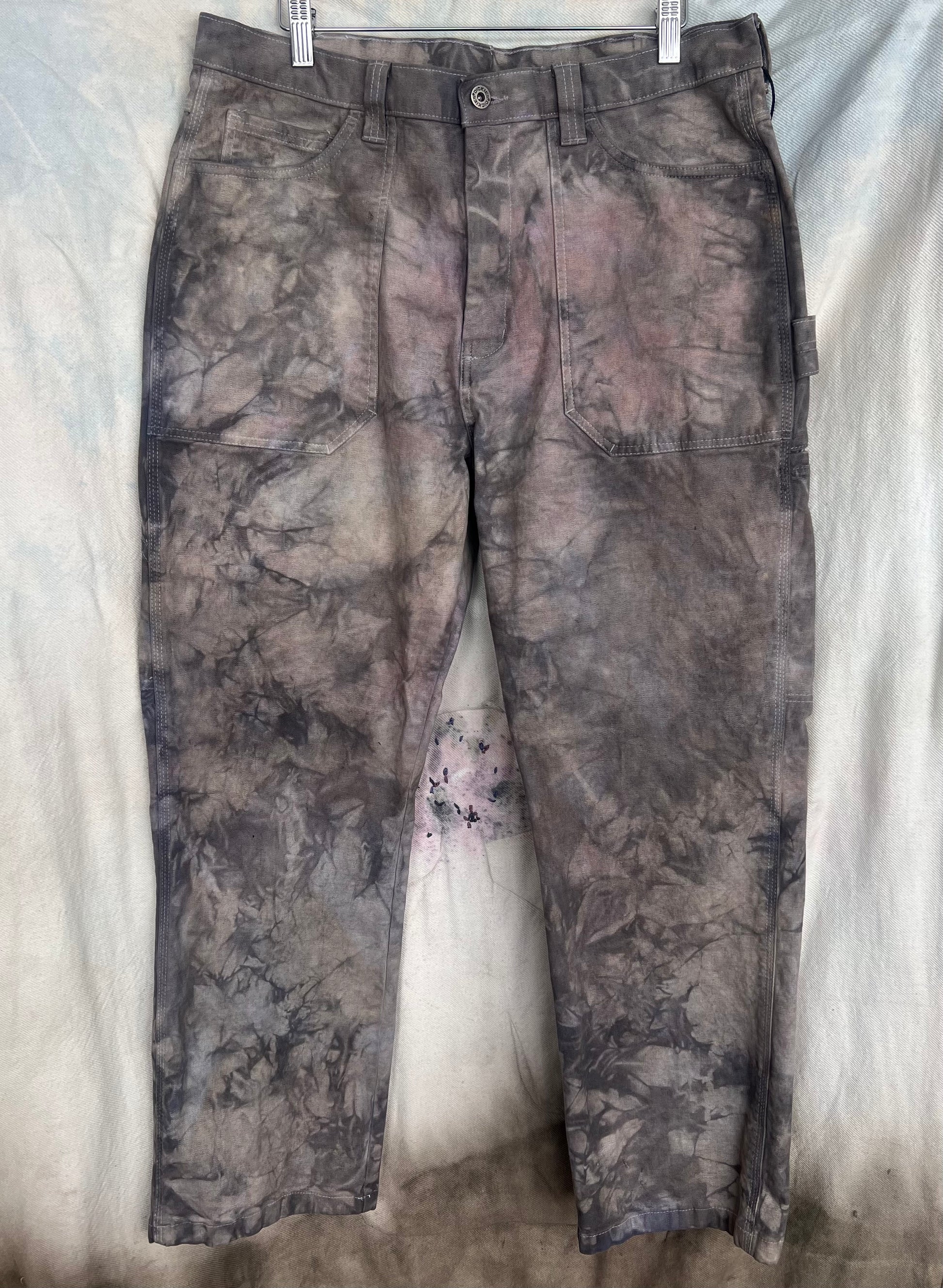 Camouflage pants hanging on a white background