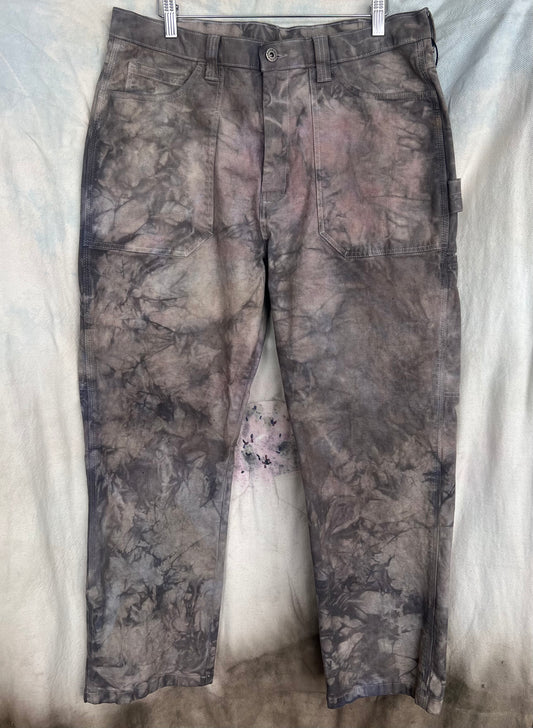 Camouflage pants hanging on a white background
