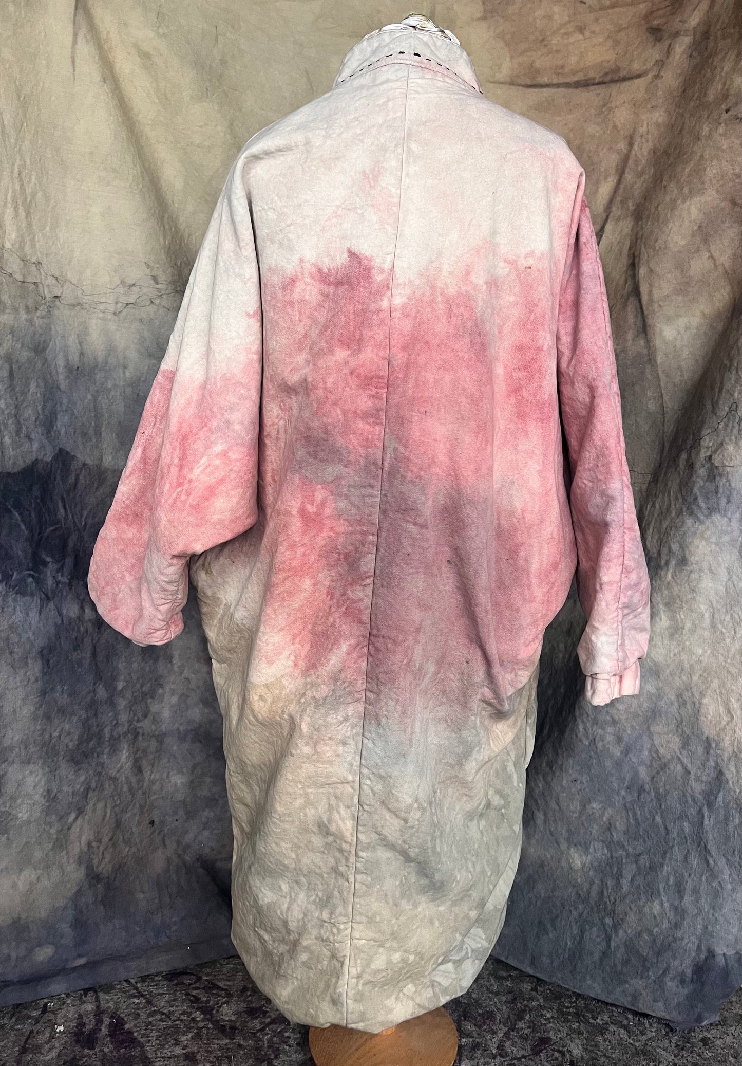 Back view of long kimono coat with pink, green, grey and yellow pattern.