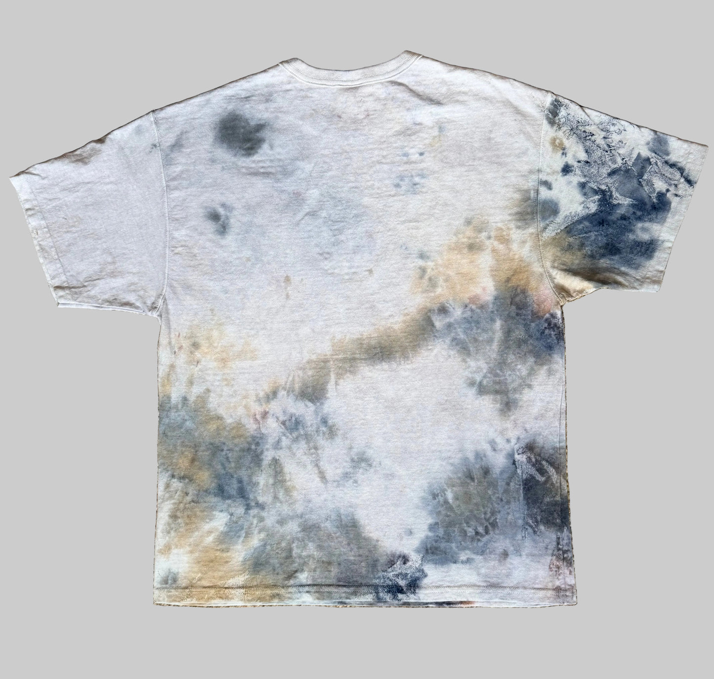 Tie-dye t-shirt with a cloud pattern on a textured brown surface