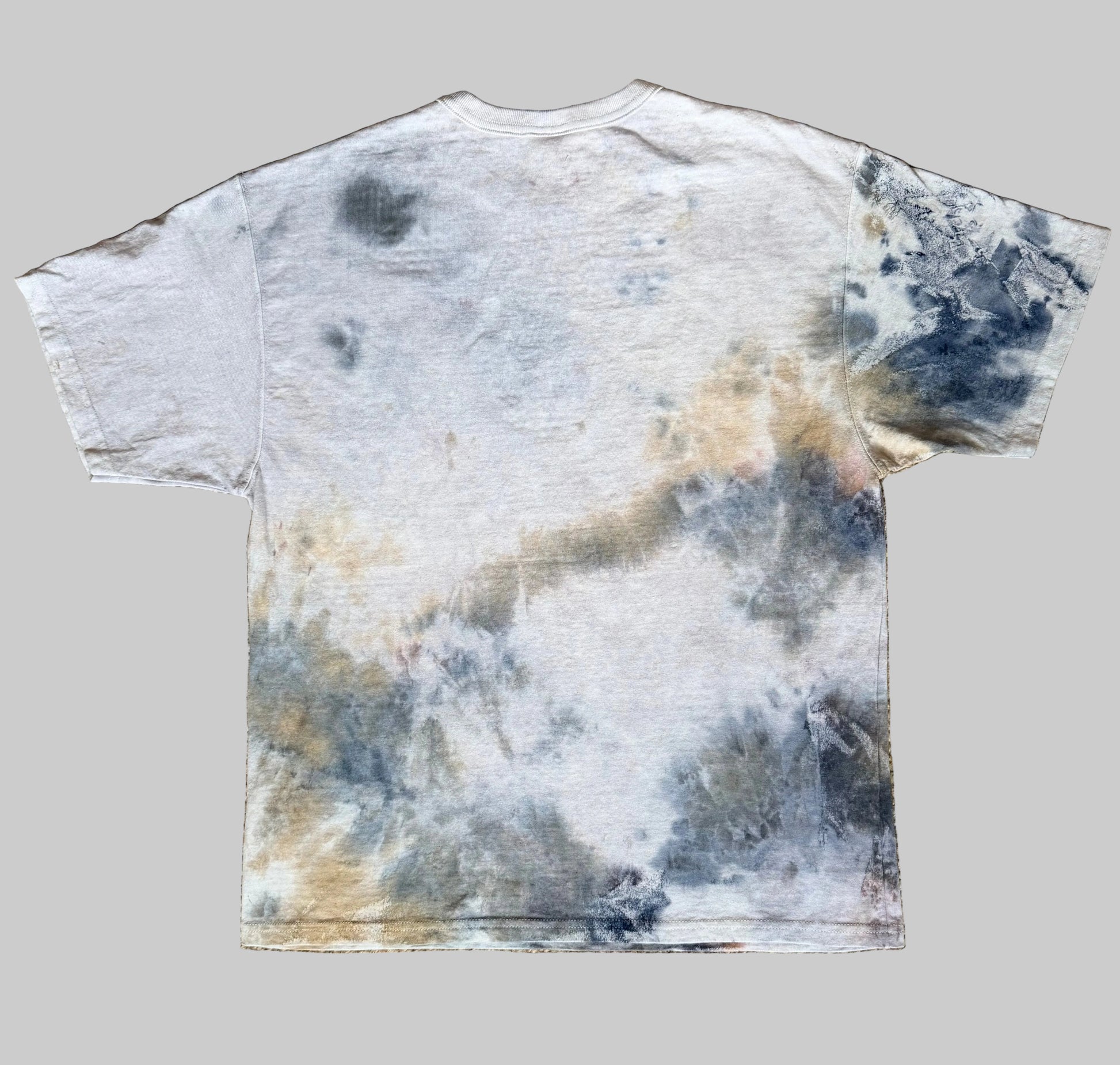 Tie-dye t-shirt with a cloud pattern on a textured brown surface
