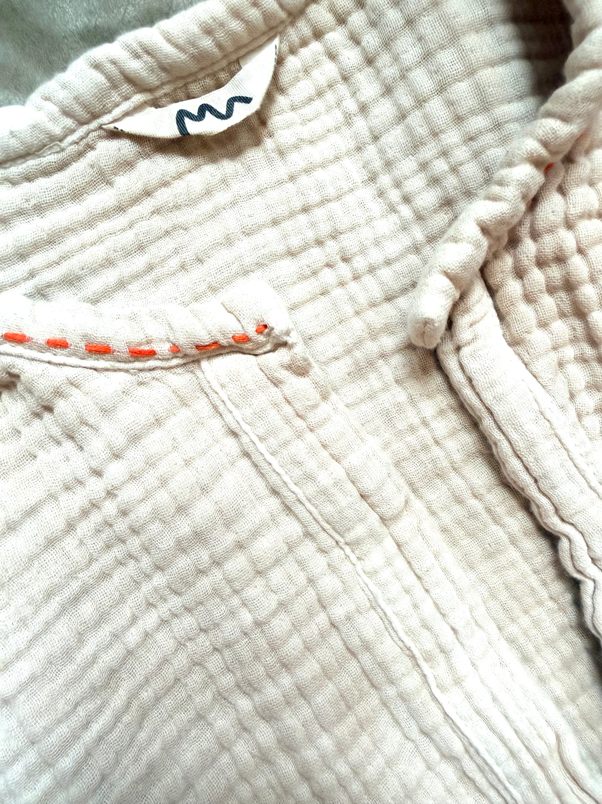 beige dress with orange embroidery along neckline