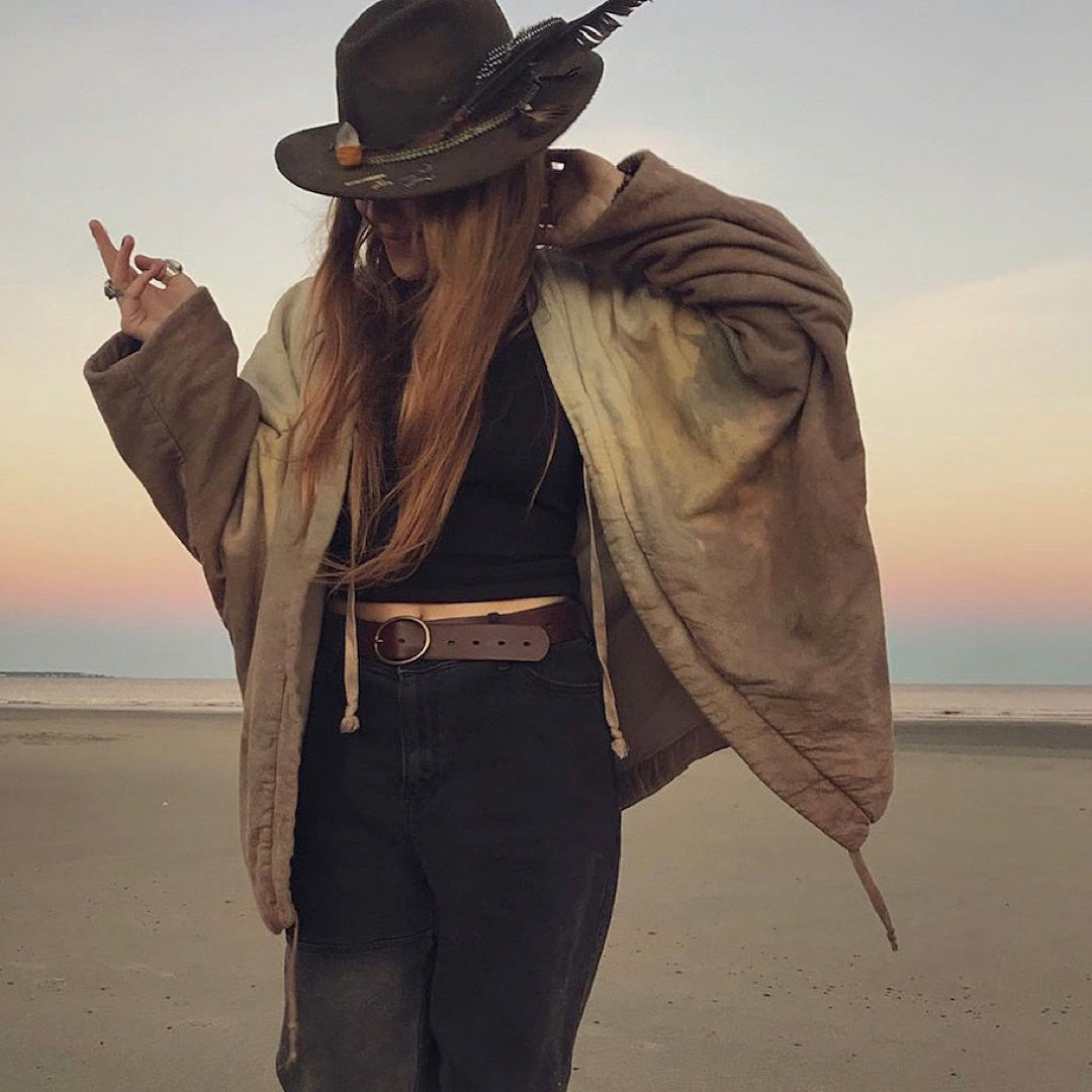 girl wearing kimono style blanket coat standing on the beach