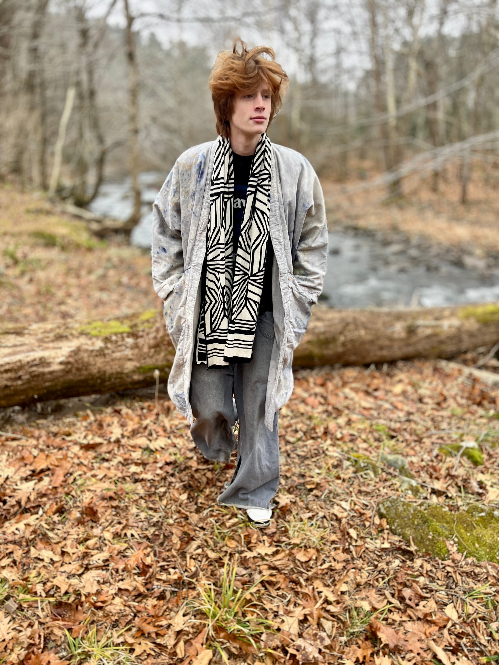 Person walking in a forest with a river in the background